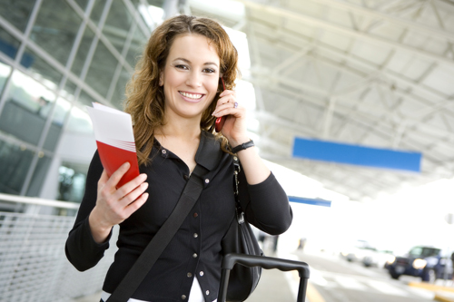 Traveler using her cell phone at an airport